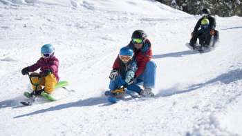 Des plaisirs de luge en famille sur la piste de luge enneigée de Malbun – petits et grands apprécient la descente dans le paradis hivernal du Liechtenstein.