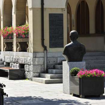 Vue sur l'entrée de l'hôtel de ville de Vaduz avec ses arrangements floraux, son buste historique et ses larges marches en pierre - un emblème culturel au centre de Vaduz.