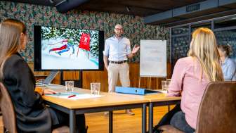 Réunion d'affaires au RUUF avec présentation des sports d'hiver Salle de conférence moderne avec des participants à une réunion d'affaires, présentation sur le ski au Liechtenstein à l'écran