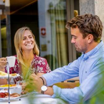 Un couple prend son petit-déjeuner en plein air sur une terrasse à Vaduz, dans une atmosphère détendue.