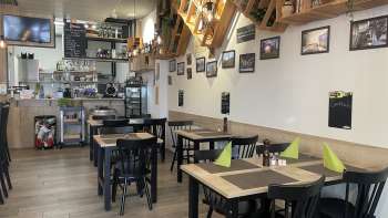 Intérieur de restaurant confortable avec des tables en bois modernes, des serviettes vertes et des éléments décoratifs