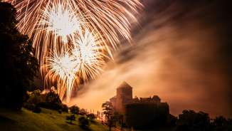 Château de Vaduz au Liechtenstein de nuit avec un grand feu d'artifice dans le ciel - photo d'ambiance avec lumière et brouillard