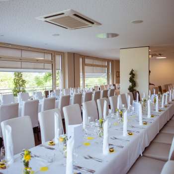 Salle solennellement décorée avec une disposition élégante des tables, des housses blanches et des détails raffinés