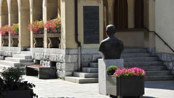 Vue sur l'entrée de l'hôtel de ville de Vaduz avec ses arrangements floraux, son buste historique et ses larges marches en pierre - un emblème culturel au centre de Vaduz.