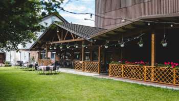 Vaste terrasse du Bangshof avec des éléments en bois, des plantes suspendues et une atmosphère chaleureuse