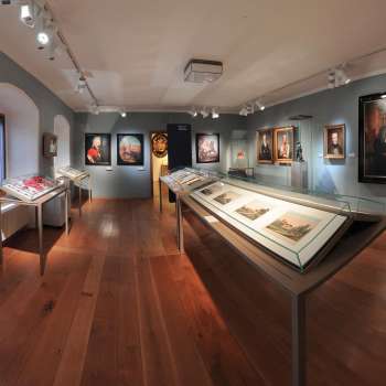 Salle d'exposition du musée national du Liechtenstein avec des portraits historiques et des objets exposés