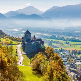 Vue du château de Vaduz au Liechtenstein avec un paysage automnal et la vallée du Rhin en arrière-plan