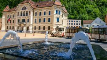 Le bâtiment du gouvernement du Liechtenstein avec une fontaine au premier plan.