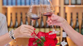 Deux personnes trinquent avec des verres de vin rouge dans la cave du Prince du Liechtenstein