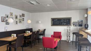  Café confortable avec des sièges modernes, un mur d'images décoratif et un sol en bois chaleureux