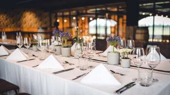 Salle de brasserie accueillante avec de longues tables en bois, des décorations de tonneaux et un éclairage stylé