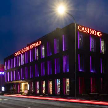 Le casino Schaanwald dans l'obscurité, éclairé de manière impressionnante par des accents de lumière violette - une destination appréciée des noctambules au Liechtenstein.