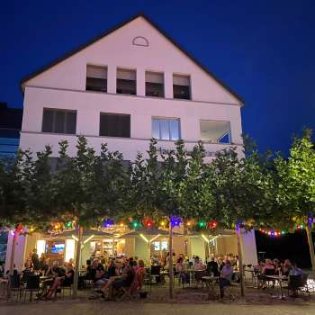 Photo d'ambiance du soir du St. Martins Pub avec terrasse illuminée et guirlandes lumineuses multicolores.