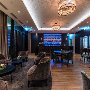 Bar confortable avec un éclairage élégant et une sélection de spiritueux.