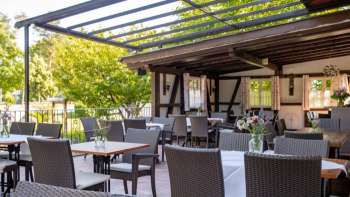 Espace extérieur accueillant avec un intérieur en bois rustique, des tables décorées et des fleurs épanouies