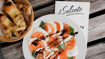 Pizza fraîche à la sauce tomate et à la roquette, servie sur une table rustique en bois