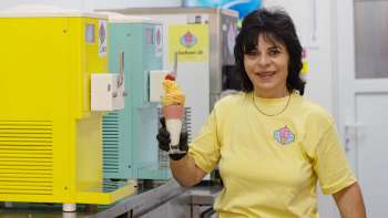 Une sympathique vendeuse de glaces tient une glace à la main au Eisbar Schaan