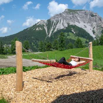 Une femme se détend sur un hamac le long du sentier des balançoires.