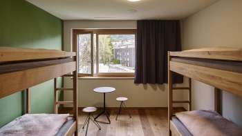 Chambre partagée lumineuse avec vue depuis la fenêtre à l'auberge de jeunesse de Schaan-Vaduz
