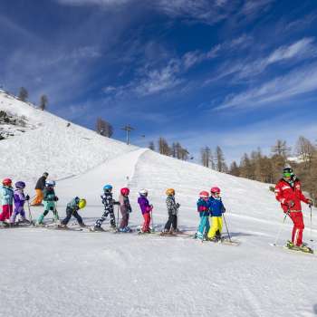 Un moniteur de ski du Malbi-Park Malbun motive les enfants sur la pente d'entraînement - un environnement parfait pour les premiers virages dans la neige.