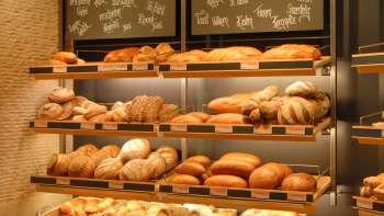 Étagère remplie de pains et autres délices à la boulangerie pâtisserie Amann