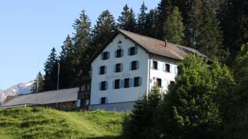 Auberge de montagne traditionnelle Sücka au milieu d'un paysage verdoyant et entourée de forêts