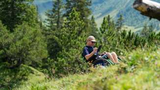 Une personne en fauteuil roulant profite du paysage alpin à Malbun - accès sans barrière à la nature au Liechtenstein