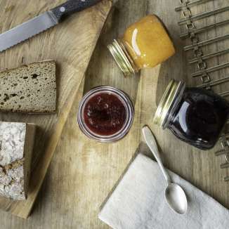 Confiture Holder fraîche avec pain de campagne et pots de confiture sur une planche en bois - savourer un petit-déjeuner traditionnel au Liechtenstein