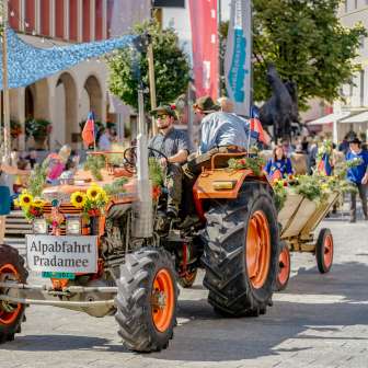 Tracteur et remorque décorés pour la fête lors de la descente d'alpage de Pradamee 2020 au Liechtenstein, entourés de spectateurs