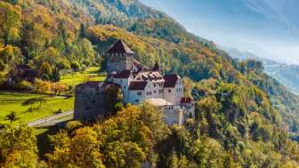 Le château de Vaduz en automne Le château de Vaduz sur une colline boisée dans un paysage d'automne au Liechtenstein