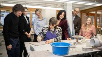 Un groupe de visiteurs intéressés observe une potière en train de modeler - expérience créative dans une atmosphère conviviale à l'atelier de céramique Schädler à Nendeln.