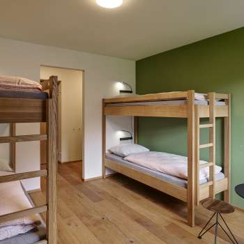 Chambre quadruple avec lits superposés et parquet à l'auberge de jeunesse Schaan/Vaduz