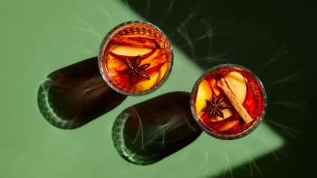 Verres remplis de vin chaud sur une table verte