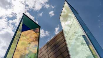 Installation artistique "Deux prismes de lumière" de Heinz Mack avec des surfaces de verre aux couleurs chatoyantes sur fond de ciel bleu. Installation artistique "Deux prismes de lumière" de Heinz Mack avec des surfaces de verre aux couleurs chatoyantes sur fond de ciel bleu.
