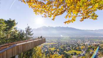 plateforme panoramique sur le sentier de découverte de la forêt à Vaduz avec vue sur la vallée ensoleillée