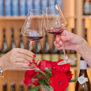 Deux personnes trinquent avec des verres de vin rouge dans la cave du Prince du Liechtenstein