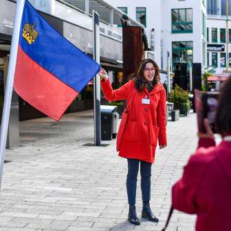 Une guide présente le drapeau du Liechtenstein lors d'une visite guidée dans le centre de Vaduz