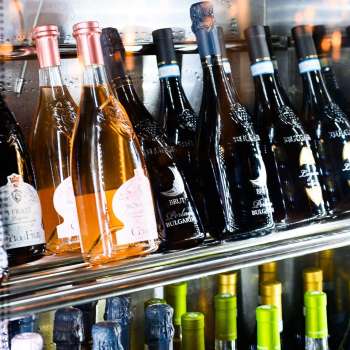 Réfrigérateur à vin bien fourni avec une sélection de vins rouges, blancs et rosés en Dolce Gusto