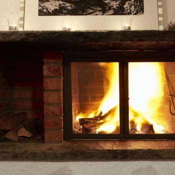 Cheminée chaude avec du bois qui brûle et une lumière d'ambiance.