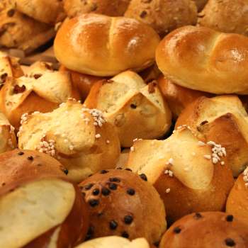Petits pains frais et pâtisseries sucrées sur le présentoir de la boulangerie Balu