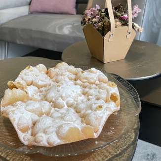 « Fasnachtsküachle » sur assiette en verre, servies dans une atmosphère chaleureuse avec décoration en arrière-plan