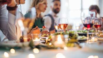 Dinner Party d'ambiance : des personnes sont assises ensemble autour d'une table festive et savourent un dîner.