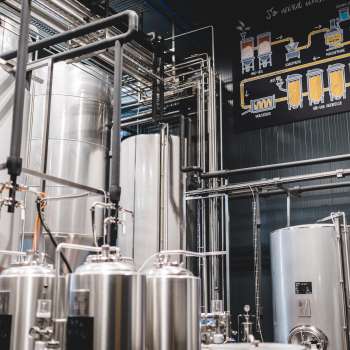 Photo technique détaillée d'un processus de brassage avec tuyauteries, cuves et schéma de fabrication de la bière.