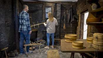 Les visiteurs explorent une ancienne cuisine à fumée au musée Walser de Triesenberg