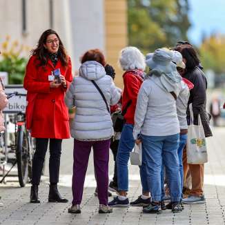 Groupe de touristes avec guide en manteau rouge lors d'une visite guidée du centre de Vaduz au Liechtenstein