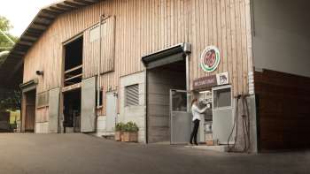 Vue extérieure du Kaiserhof au Liechtenstein avec station de lait en libre-service – régionale, fraîche et directement de la ferme.