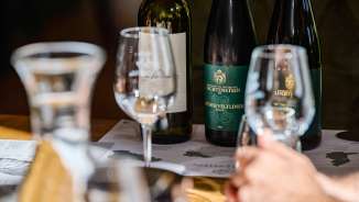 Gros plan sur des verres à vin et des bouteilles de vin de la Hofkellerei Liechtenstein lors d'une dégustation professionnelle de Grüner Veltliner