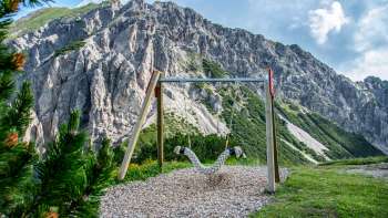 Balançoire devant un impressionnant décor de montagnes au Liechtenstein