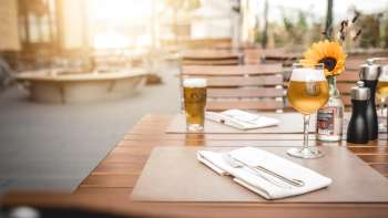 Salles de restaurant modernes avec d'élégantes tables en bois, des lampes créatives et une atmosphère chaleureuse