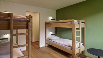 Chambre à quatre lits avec lits superposés et parquet à l'auberge de jeunesse de Schaan-Vaduz